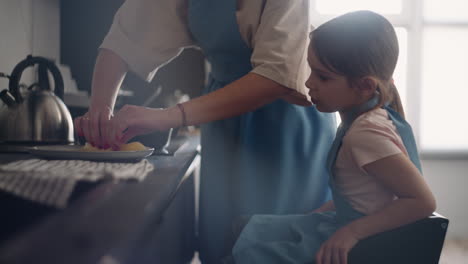 Sorgfältige-Mutter-Füttert-Ihre-Kleine-Tochter-Mit-Frisch-Gebackenen-Pfannkuchen.-Frau-Und-Kind-Kochen-Zusammen